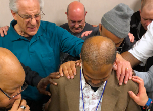 Men pray in group together