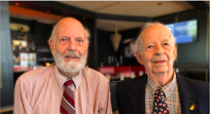 Two well dressed men pose for the camera