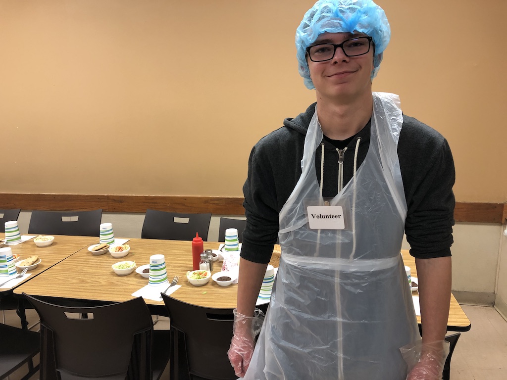 Shelter KC Volunteer posing in front of dining room table