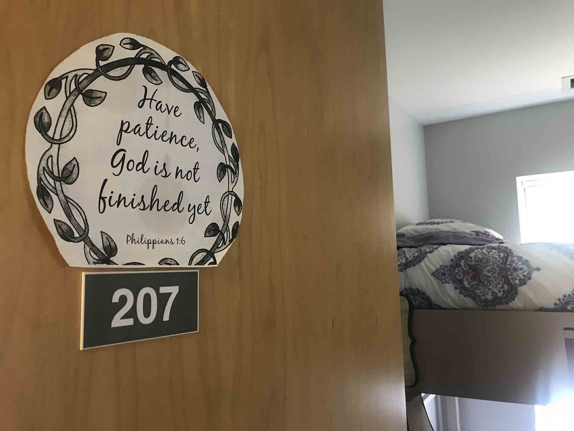 "Have Patience, God is not finished yet" sign on the door to a room at Shelter KC