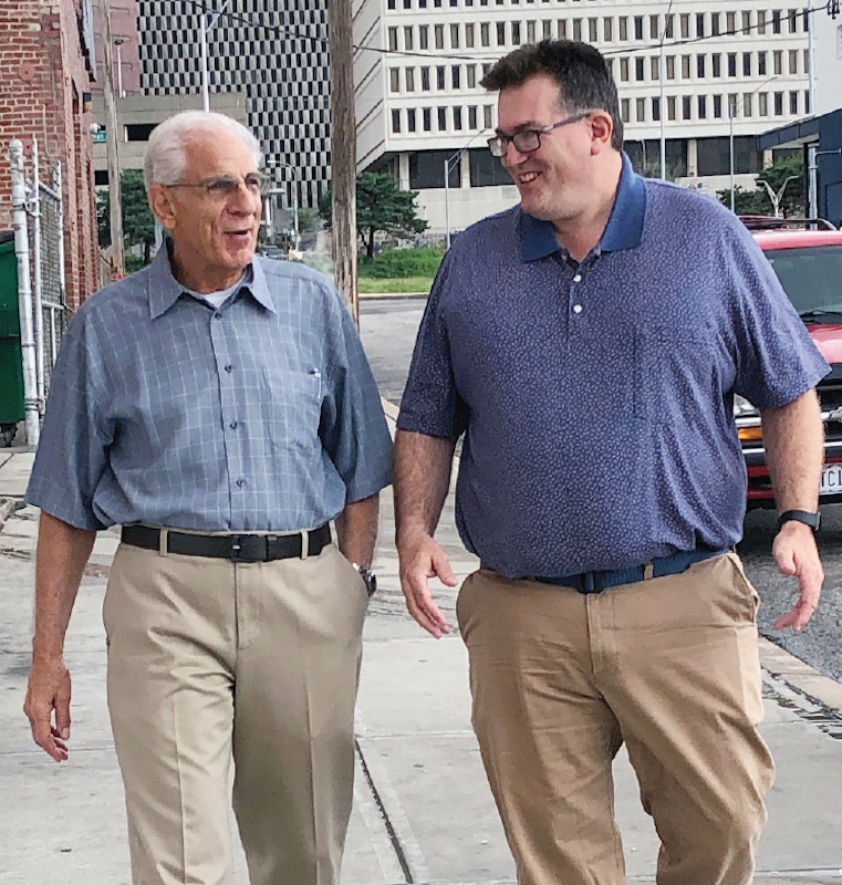 Joe Colaizzi and Eric Burger walk down street talking